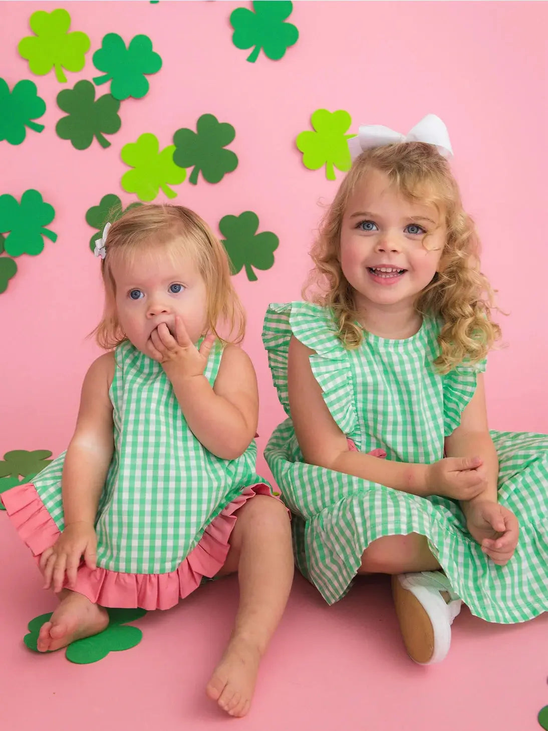 Two girls in spring green gingham dress with pink bows.