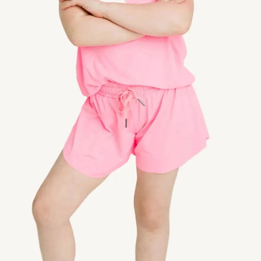 Person wearing a pink outfit with shorts and a top on a white background