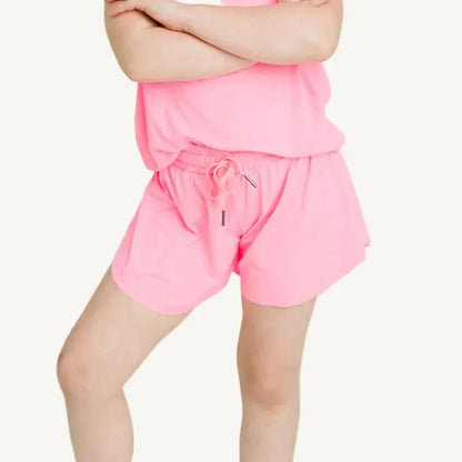 Person wearing a pink outfit with shorts and a top on a white background