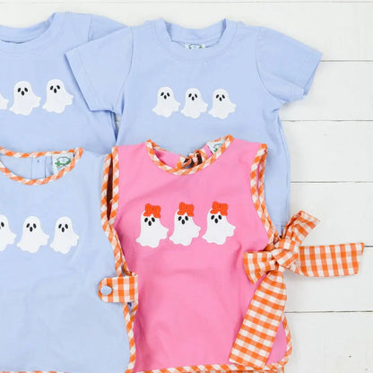 Set of children's shirts with ghost designs on a wooden surface