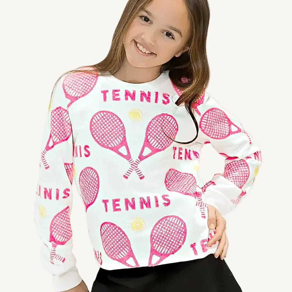 A pink sequin sweatshirt with tennis rackets and balls and a white background.