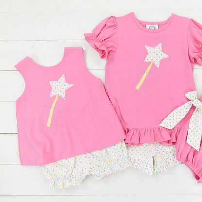 Set of pink children's clothing with floral details on a white background